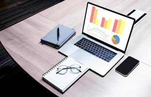 Top view presentation on display laptop with notebook and glasses on table in meeting room photo