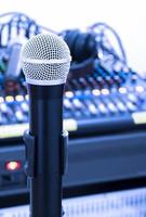 The microphone on tripod with mixer background in sound control room. photo