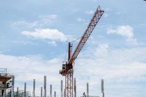 grúa de construcción de torre en el sitio de construcción de edificios con fondo de cielo azul foto