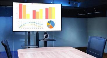 Mock up chart slide show presentation on display television with camera webcam in meeting room photo