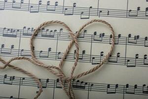 hilo de lino colocado sobre papel con notas musicales