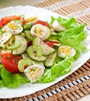 Salad of tomatoes, cucumbers and quail eggs photo