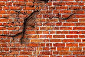 Detailed close up view on very old and weathered brick walls with cracks photo