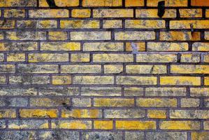 Detailed close up view on very old and weathered brick walls with cracks photo