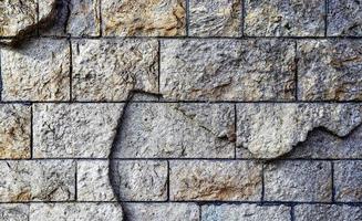 Detailed close up view on very old and weathered brick walls with cracks photo