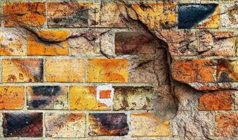 Detailed close up view on very old and weathered brick walls with cracks photo
