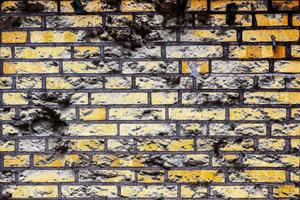 Detailed close up view on very old and weathered brick walls with cracks photo