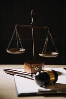 Justice and law concept.Male judge in a courtroom with the gavel, working with, computer and docking keyboard, eyeglasses, on table in morning light photo