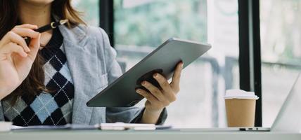 Woman hand using smart phone and laptop in outdoor nature park and sunset sky with bokeh light abstract background. Technology business and freelance working concept. Vintage tone filter color style. photo