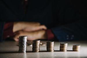 businesswoman hand puting coins in glass for saving money. concept finance and accounting photo