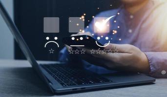 servicio al cliente y concepto de satisfacción, gente de negocios tocando la pantalla virtual en el icono de la cara feliz para dar satisfacción en el servicio. calificación muy impresionado. foto