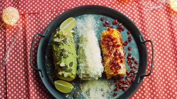 Mexican corn elote in three ways. Pressed with cheese, guacamole and pomegranate. Maxican flag video