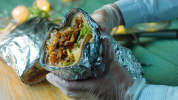 Very large burrito with avocado and chorizo meat. Filming in a romantic setting. Macro shooting video