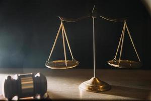 Business and lawyers discussing contract papers with brass scale on desk in office. Law, legal services, advice, justice and law concept photo