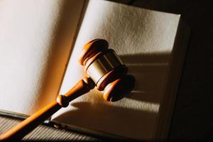 law books and scales of justice on desk in library of law firm. jurisprudence legal education concept. photo