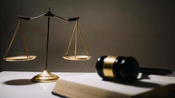 Business and lawyers discussing contract papers with brass scale on desk in office. Law, legal services, advice, justice and law concept photo