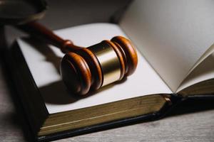 Justice and law concept.Male judge in a courtroom with the gavel, working with, computer and docking keyboard, eyeglasses, on table in morning light photo