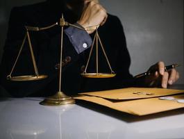 Business and lawyers discussing contract papers with brass scale on desk in office. Law, legal services, advice, justice and law concept photo