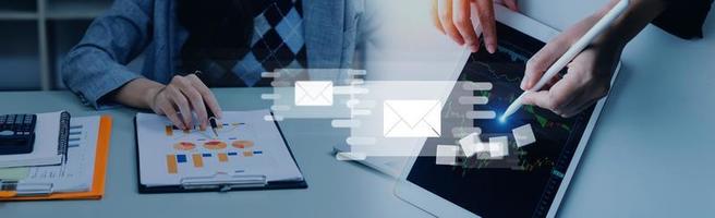 Businessman hands using Laptop typing on keyboard and surfing the internet on office table with email icon, email marketing concept, send e-mail or newsletter, online working internet network. photo
