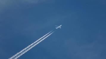 avion de passagers traverse le ciel en laissant une traînée de fumée. concept de tourisme et de voyage video