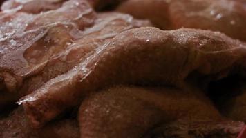 Close-up view of hands in gloves packing chicken legs from a box into individual plastic bags. Process of freezing meat for further use at home. 4k video with light play