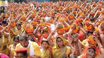 new delhi, india, 03 april 2022 - vrouwen met kalash op hoofd tijdens jagannath tempel mangal kalash yatra, indische hindoe toegewijden dragen aarden potten met heilig water met een kokosnoot erop video