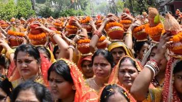 nova delhi, índia 03 de abril de 2022 - mulheres com kalash na cabeça durante o templo jagannath mangal kalash yatra, devotos hindus indianos carregam potes de barro contendo água sagrada com um coco no topo video