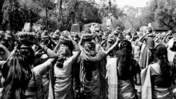 Delhi, India April 03 2022 - Women with Kalash on head during Jagannath Temple Mangal Kalash Yatra, Indian Hindu devotees carry earthen pots containing sacred water with coconut on top-Black and White video