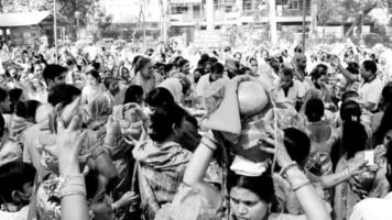 Delhi, Indië april 03 2022 - Dames met kalash Aan hoofd gedurende jagannath tempel mangal kalash jatra, Indisch Hindoe toegewijden dragen aarden potten met heilig water met kokosnoot Aan top-zwart en wit video