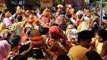 nova delhi, índia 03 de abril de 2022 - mulheres com kalash na cabeça durante o templo jagannath mangal kalash yatra, devotos hindus indianos carregam potes de barro contendo água sagrada com um coco no topo video