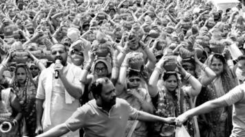 delhi, índia, 03 de abril de 2022 - mulheres com kalash na cabeça durante o templo jagannath mangal kalash yatra, devotos hindus indianos carregam potes de barro contendo água sagrada com coco no topo-preto e branco