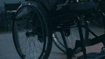 Side view of one American male workers in a workshop at a factory making wheelchairs, sitting at a workbench using hand tools and assembling parts of a product, sitting in wheelchairs video