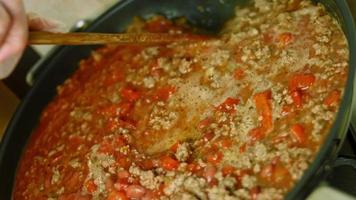 Alle Zutaten mit einem Holzlöffel vermischen. chili con carne kochen, mexikanische küche video