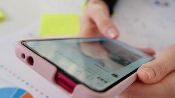 Female using smartphone on office work. video