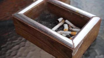 Nahaufnahme von Zigarettenkippen in einem Aschenbecher video