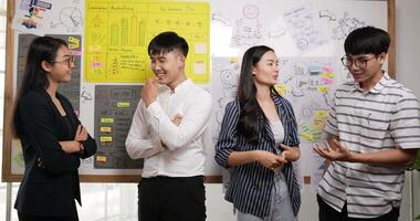 portrait de groupe d'une équipe de jeunes entreprises souriantes et prospères, regardez la caméra et montrez les pouces vers le haut en se tenant debout avec l'arrière-plan du tableau de bord. entreprise, start-up, concept d'objectif. video