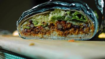 The chef arranges the aluminum foil in a very large burrito video