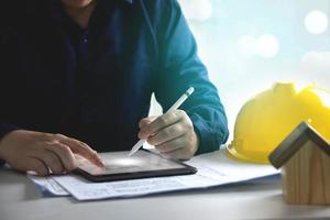 House plan design, house structure blueprint. Engineers use tablets to design blueprints and analyze building structures. Architect concept, technology in design photo