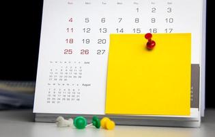 alfiler en el calendario con notas post-it para escribir. concepto de cita notificación de fecha importante una cita con su médico o programar una reunión con espacio de copia para diseño de negocios foto