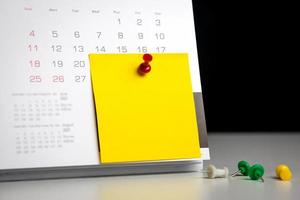 alfiler en el calendario con notas post-it para escribir. concepto de cita notificación de fecha importante una cita con su médico o programar una reunión con espacio de copia para diseño de negocios foto