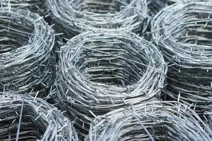 Rolls of barbed wire. Barbed wire is used for make fences , secure property and make border to show the territory of  area. photo