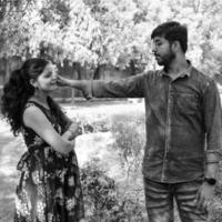 pareja india posando para una sesión de fotos de maternidad. la pareja está posando en un césped con hierba verde y la mujer está faluntando su panza en el jardín de lodhi en nueva delhi, india - blanco y negro