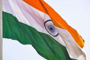 India flag flying high at Connaught Place with pride in blue sky, India flag fluttering, Indian Flag on Independence Day and Republic Day of India, tilt up shot, Waving Indian flag, Har Ghar Tiranga photo