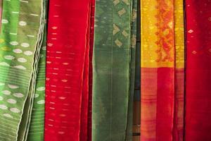 Bangladeshi Women,s Traditional Colorful Jamdani saree hanging in the retail Showrooms. Colorful Jamdani Saree Texture Background photo