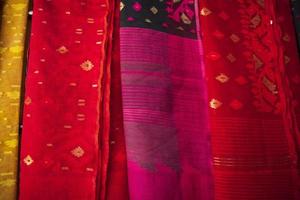 Bangladeshi Women,s Traditional Colorful Jamdani saree hanging in the retail Showrooms. Colorful Jamdani Saree Texture Background photo