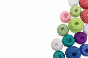 Multicolored balls and bobbins of woolen yarn, wooden thread sleeves on white isolated background. Needlework, handmade.  view from above. Isolated. Copy space photo