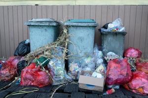 montones de desechos domésticos que exceden la capacidad de los botes de basura por lo que huelen mal foto