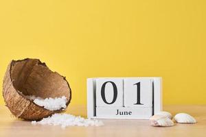 Wooden block calendar with date June 1 on the yellow background photo