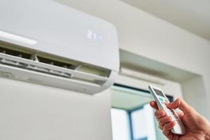 Hand adjusting temperature on air conditioner photo