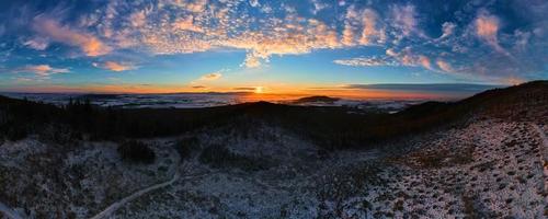 Sunset over mountains covered with forest photo